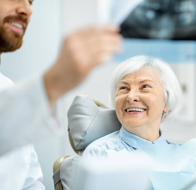 Older female patient talking to periodontist